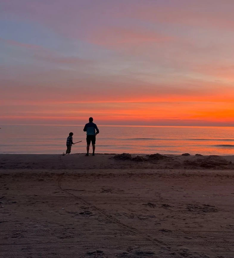 Father and sun on the beach during sunset