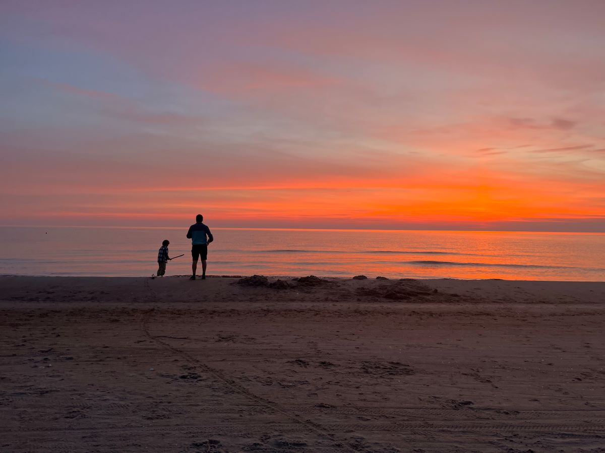 Father and sun on the beach during sunset